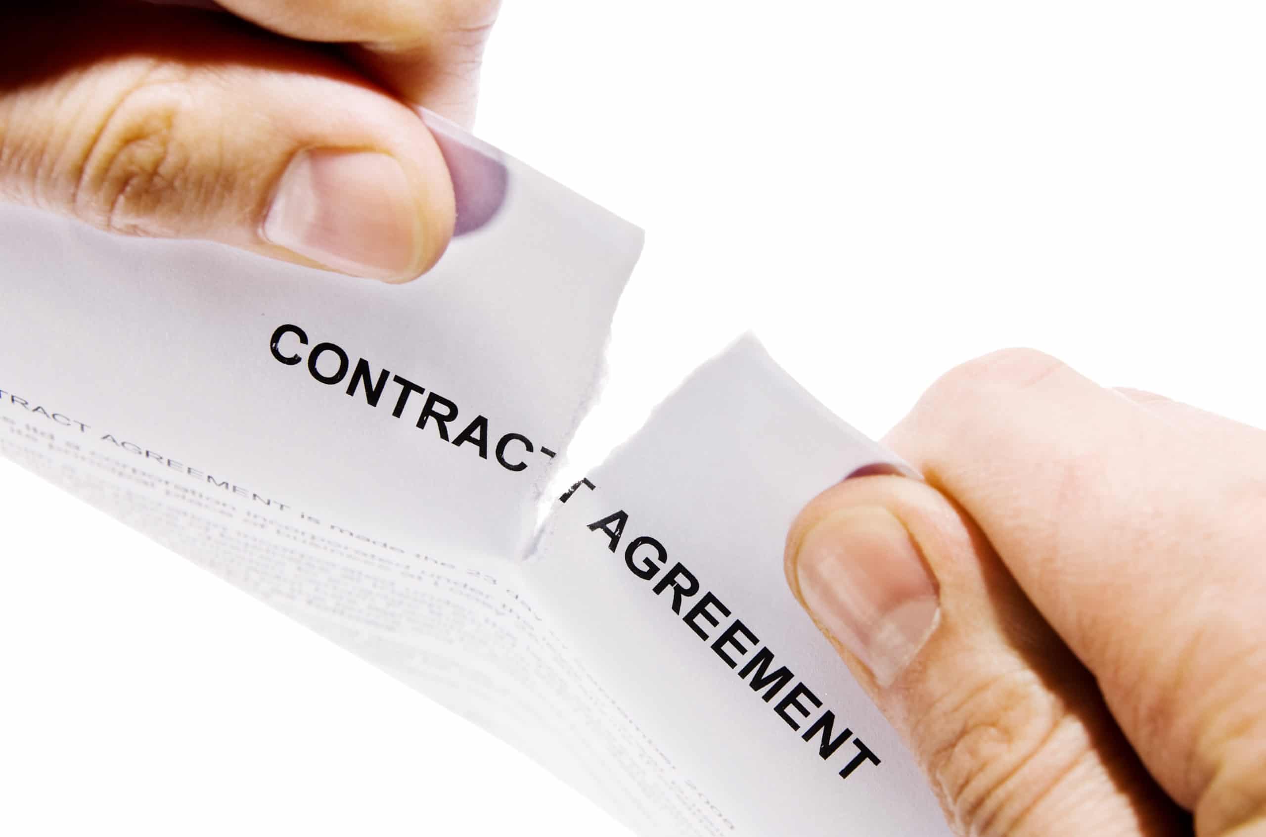 Hands ripping contract agreement document