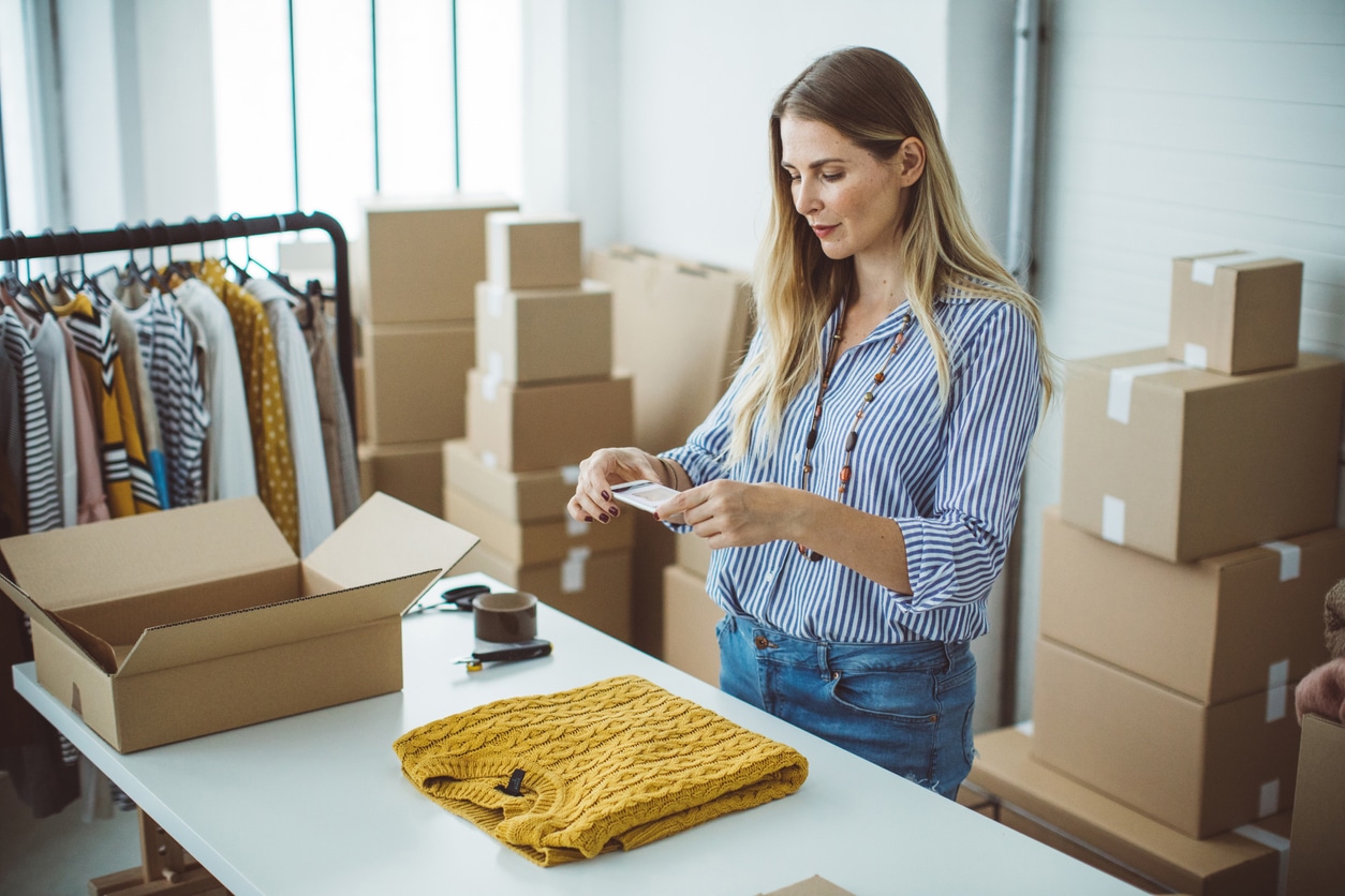 Women, owener of small business packing product in boxes, preparing it for delivery.