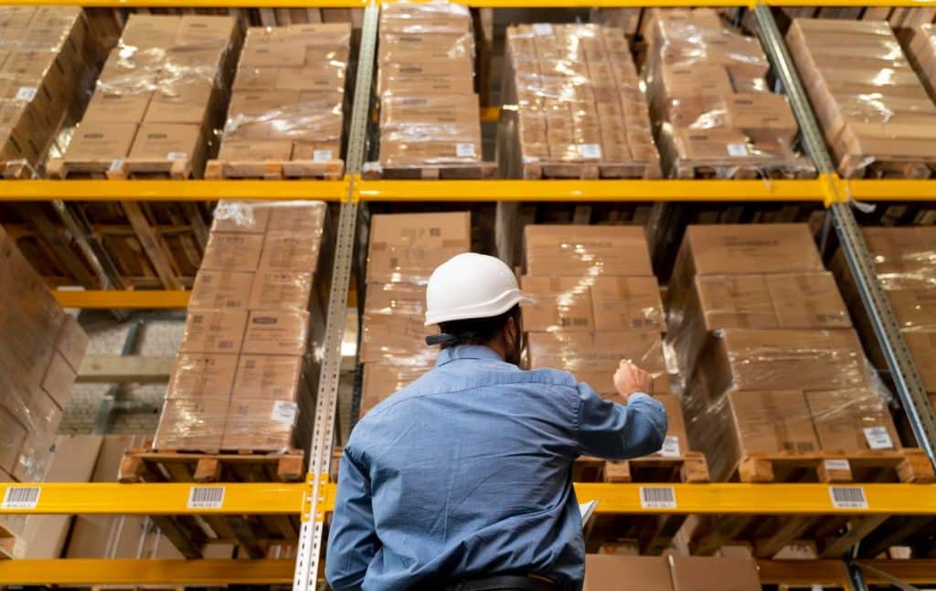 Man calculating storage limits in Amazon warehouse.