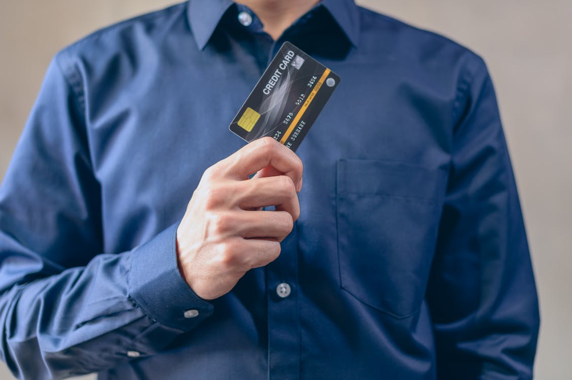 Image of a man holding up a credit card.